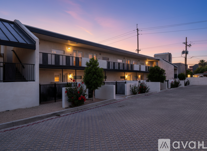 A row of modern townhouses with balconies and flower pots in front.