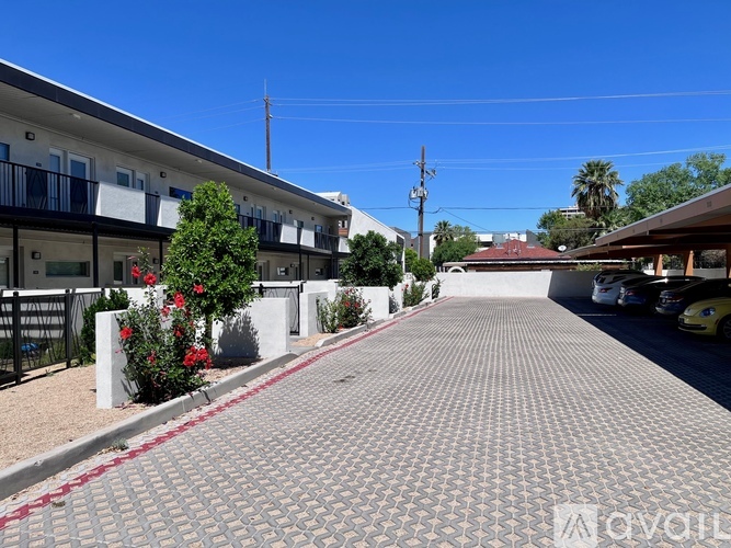 A street view of a residential area with apartment buildings and parked cars.