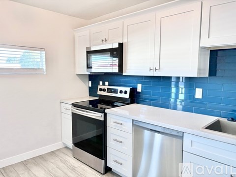A kitchen with white cabinets and a black stove top oven.
