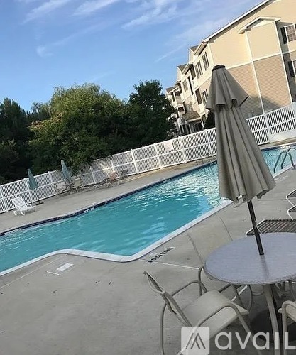 A pool with a table and chairs and an umbrella.