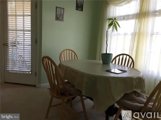 A dining room with a table and chairs.