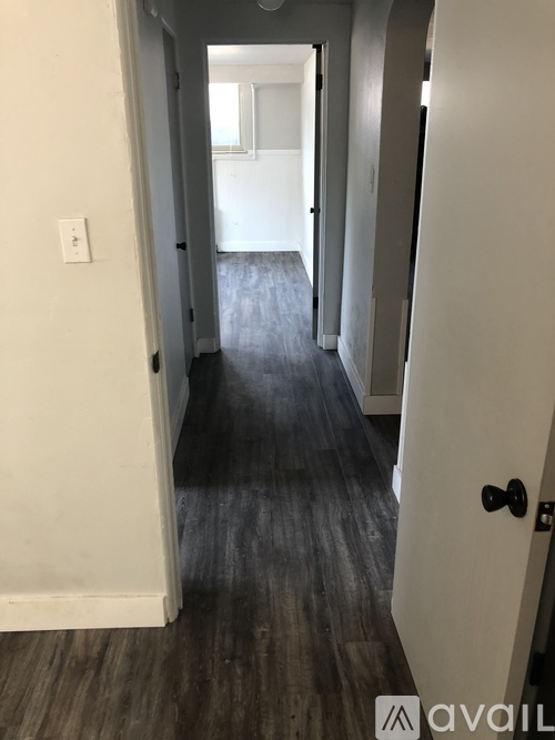 A hallway with a black door and a white door.