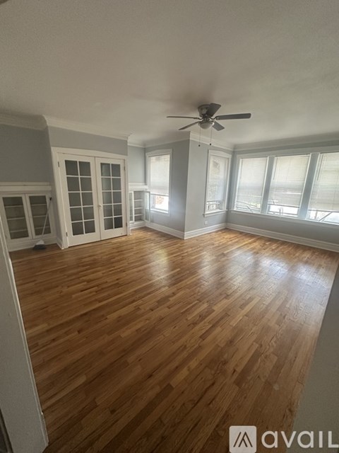 A room with wooden flooring and a ceiling fan.