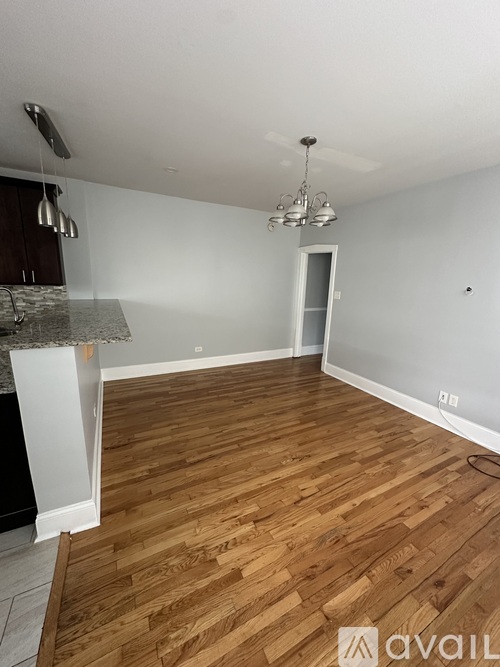 A room with wooden flooring and a ceiling fan.