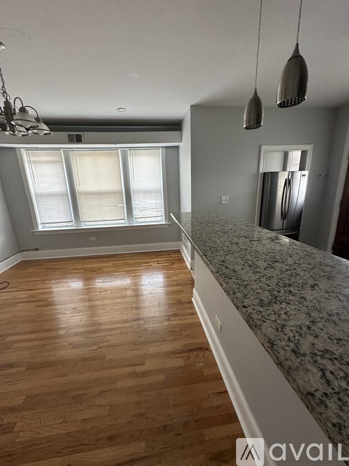 A kitchen with wooden floors and a granite countertop.
