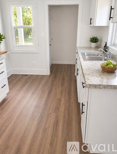 A kitchen with white appliances and wooden floors.