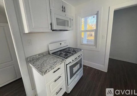 A kitchen with white cabinets and a granite countertop.