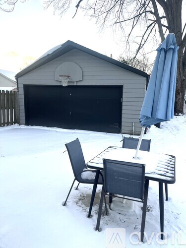 A snow-covered patio with a table and chairs.