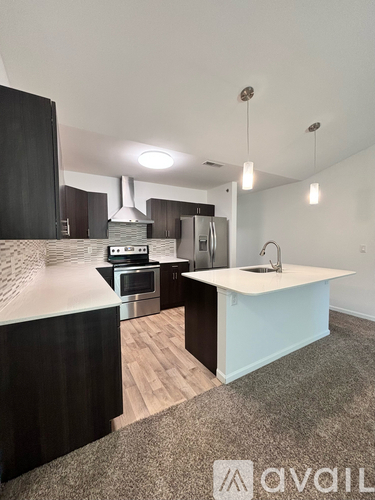 A kitchen with a stove, sink, and refrigerator.