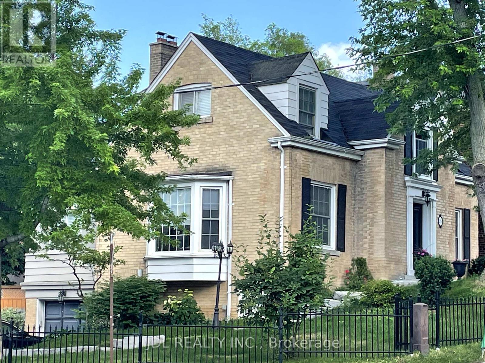 A large house with a black fence in front.