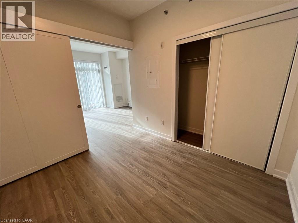 A room with wooden flooring and a doorway leading to another room.