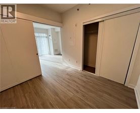 A room with wooden flooring and a doorway leading to another room.