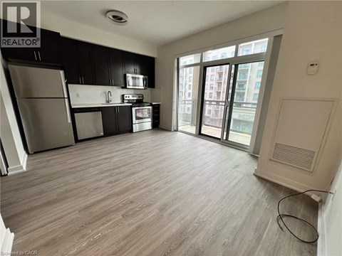 A kitchen with black cabinets and stainless steel appliances.