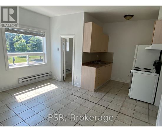 A kitchen with a window and a door leading to another room.