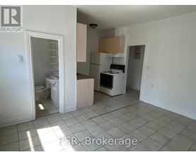 A kitchen with white appliances and a tile floor.