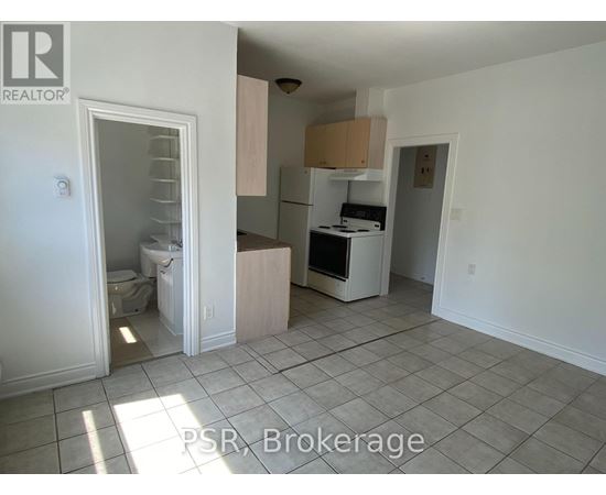 A kitchen with white appliances and a tile floor.
