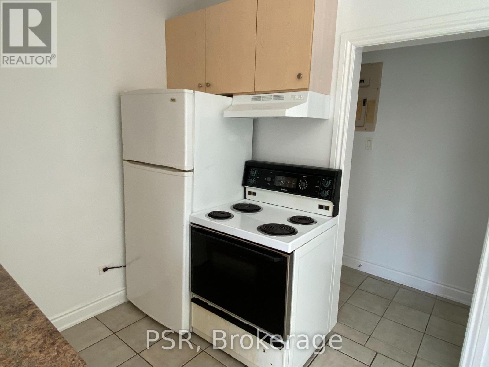 A small kitchen with a white refrigerator and a white stove top oven.