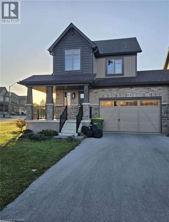 A house with a garage and a driveway in front of it.
