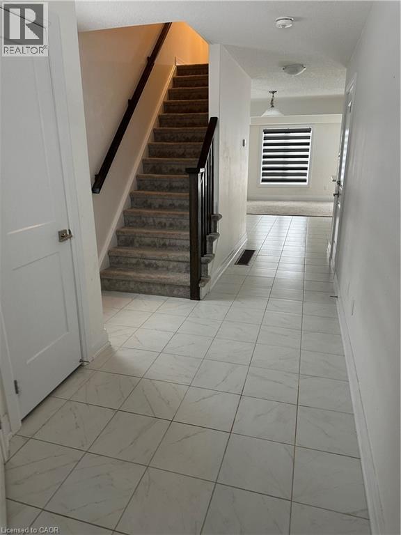 A hallway with a staircase and a door.