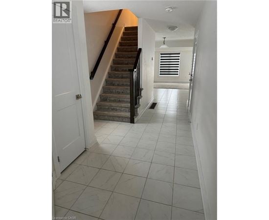 A hallway with a staircase and a door.