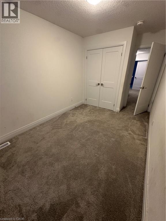 A bedroom with a carpeted floor and a white door.