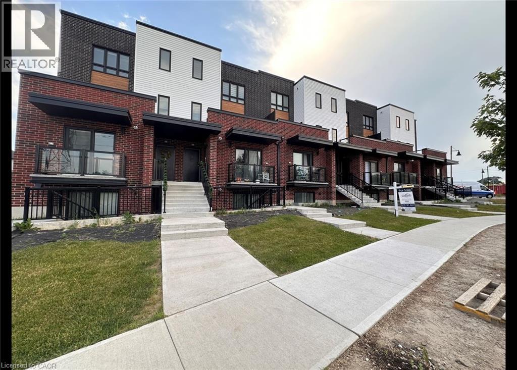 A row of modern townhouses with a walkway in front.