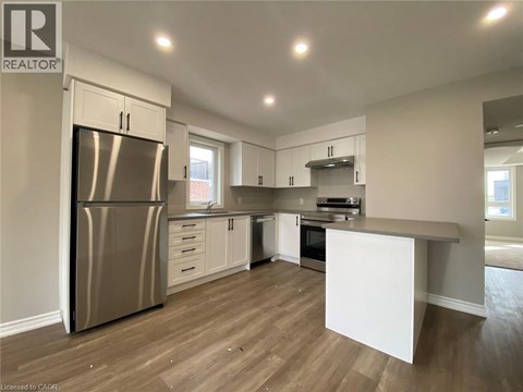 A kitchen with a refrigerator, oven, and countertops.