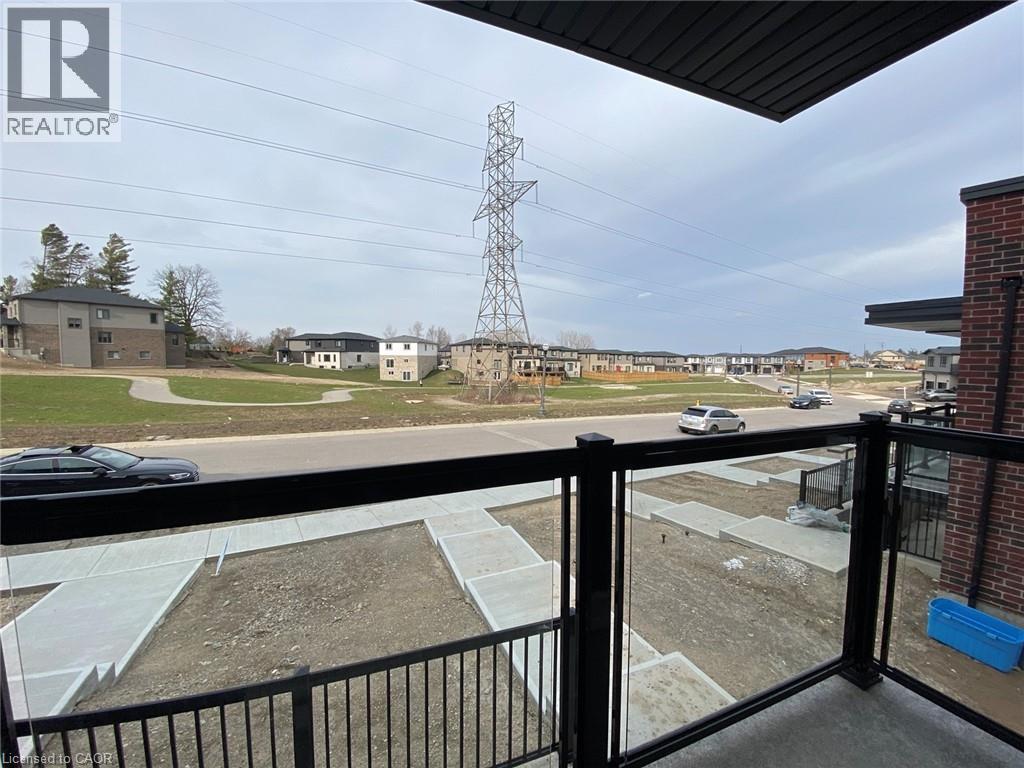 A view from a balcony overlooking a parking lot and a large power line tower.