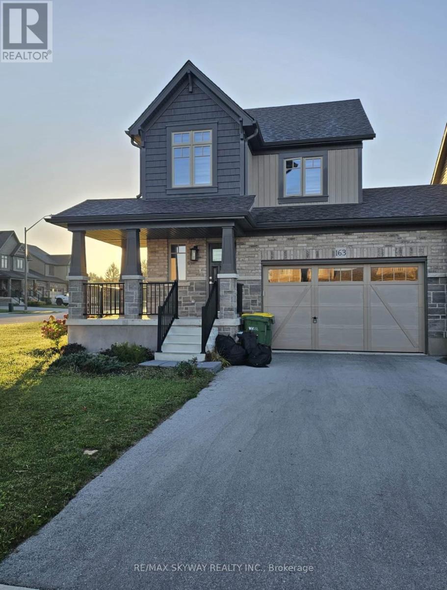 A house with a garage and a driveway in front of it.