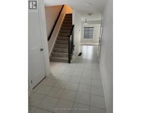 A hallway with a staircase and a door.