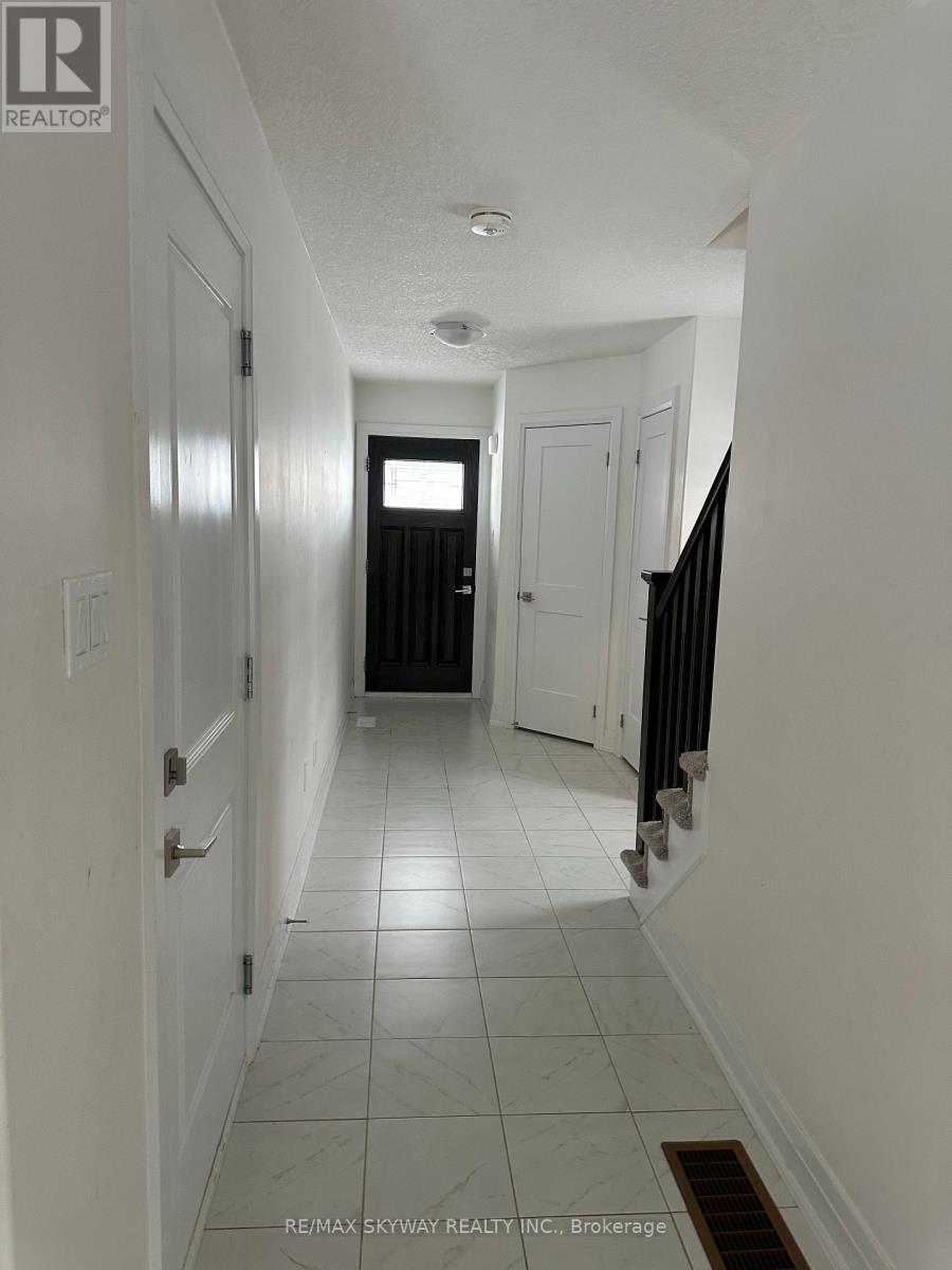 A hallway with white walls and tile flooring.