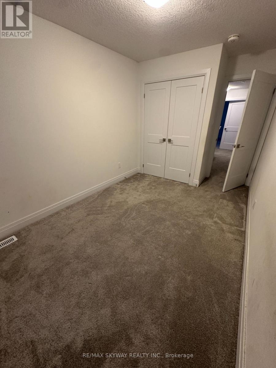 A bedroom with a carpeted floor and a white door.