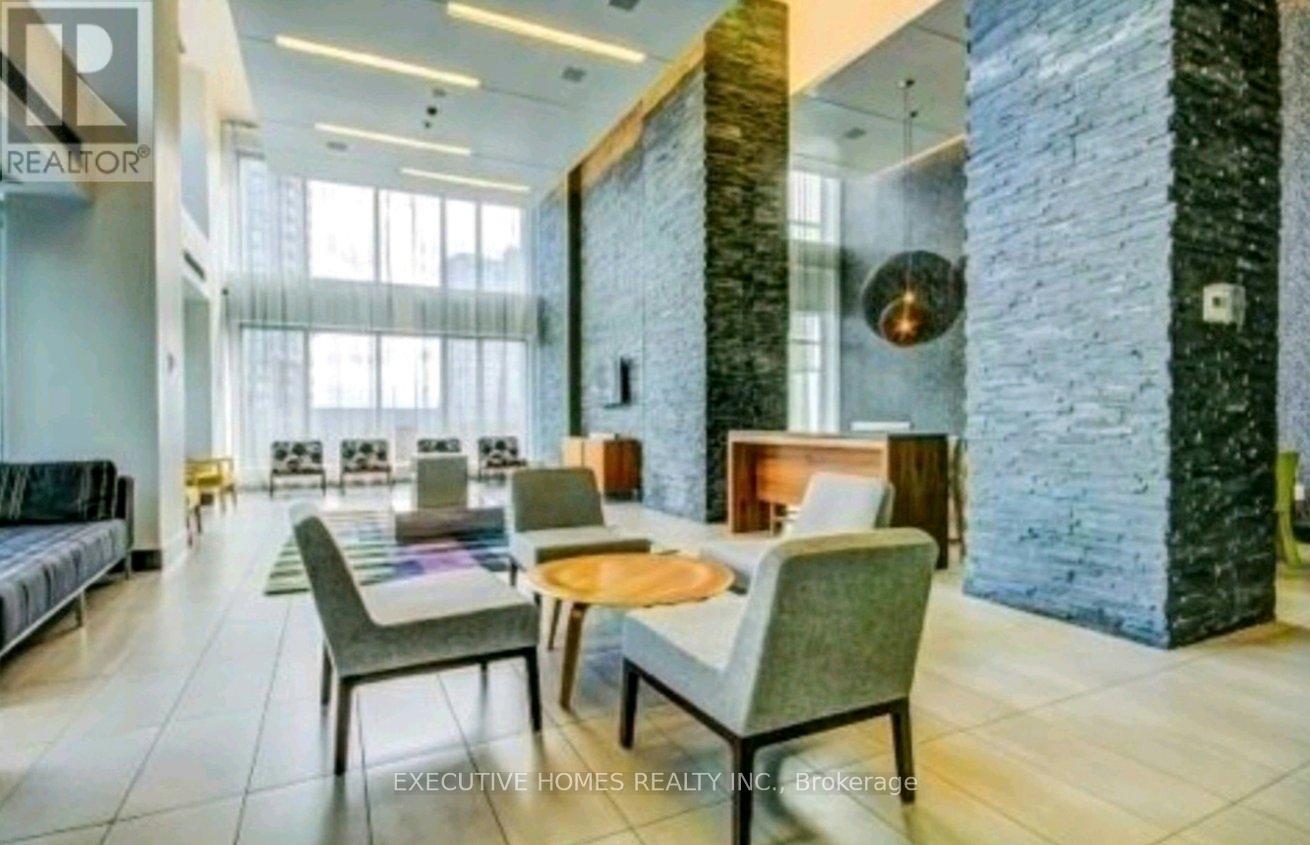 A modern living room with a stone pillar and a dining table set up.