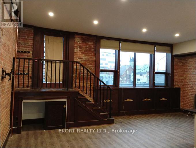 A room with a staircase and brick walls.