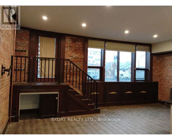 A room with a staircase and brick walls.