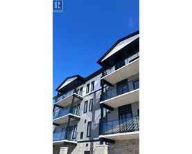 A modern building with balconies and a clear blue sky.