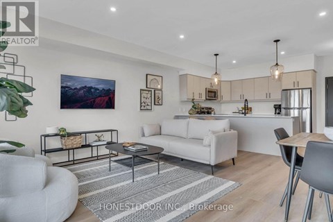 A modern living room with a white sofa, a grey armchair, and a coffee table.