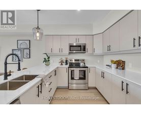 A modern kitchen with white cabinets and stainless steel appliances.