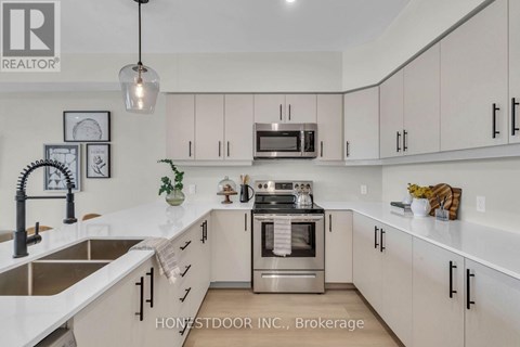 A modern kitchen with white cabinets and stainless steel appliances.