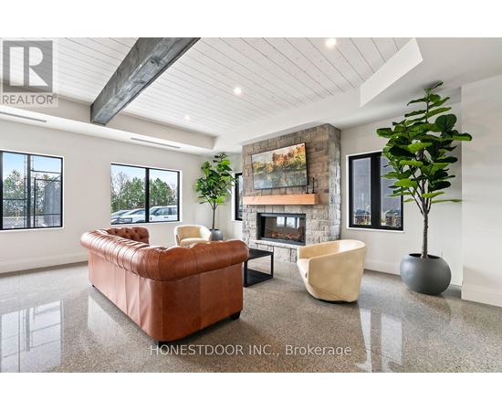 A living room with a brown leather couch, a fireplace, and a large painting on the wall.