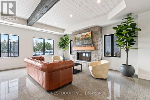 A living room with a brown leather couch, a fireplace, and a large painting on the wall.