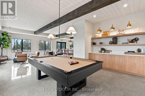 A pool table is in the middle of a room with a wood ceiling and a white wall.