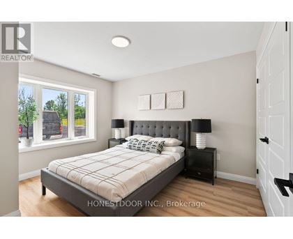 A bedroom with a bed, nightstand, and window.