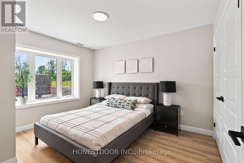 A bedroom with a bed, nightstand, and window.