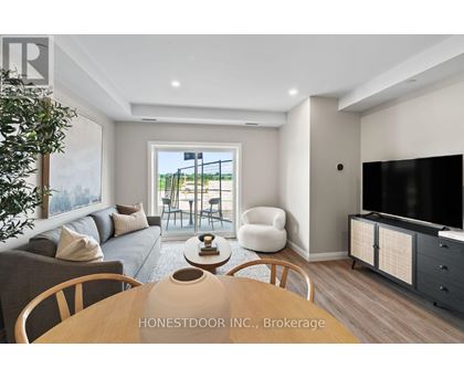 A modern living room with a wooden table and chairs, a grey sofa, and a television.