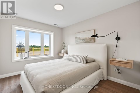 A bedroom with a large bed and a window overlooking a yellow fence.