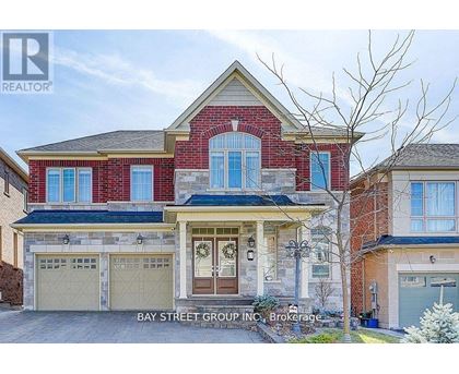 A two-story house with a red brick facade and a garage.