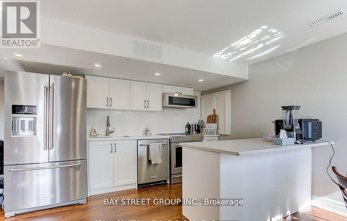A modern kitchen with a refrigerator, cabinets, and a countertop.