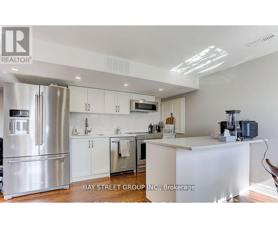 A modern kitchen with a refrigerator, cabinets, and a countertop.