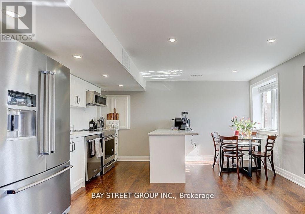A modern kitchen with stainless steel appliances and a dining table set for four.